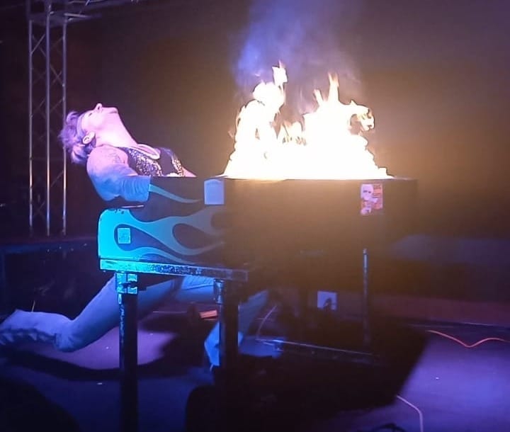 Brandon Giles at a flaming piano. 